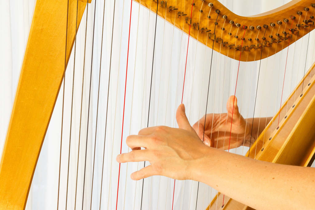 Playing the Celtic Harp - Close up hands playing celtic harp. Fingers are on the snares.